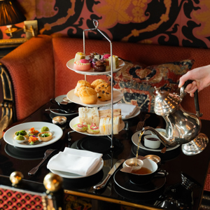 Vegan afternoon tea served on a three-tier stand in the opulent Rhubarb restaurant at Prestonfield House, Edinburgh, with plant-based savouries, scones and pastries