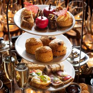 Three-tier stand of elegant vegetarian afternoon tea at Prestonfield House, Edinburgh, featuring savouries, scones and pâtisserie in a luxurious candlelit setting