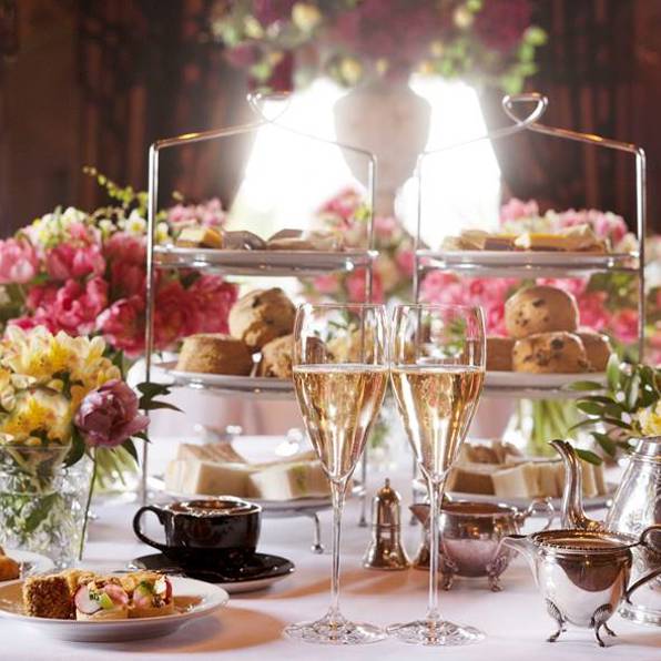 Champagne, tea, silver cake stands and pink flowers shown in Rhubarb, the best Edinburgh restaurant for afternoon tea